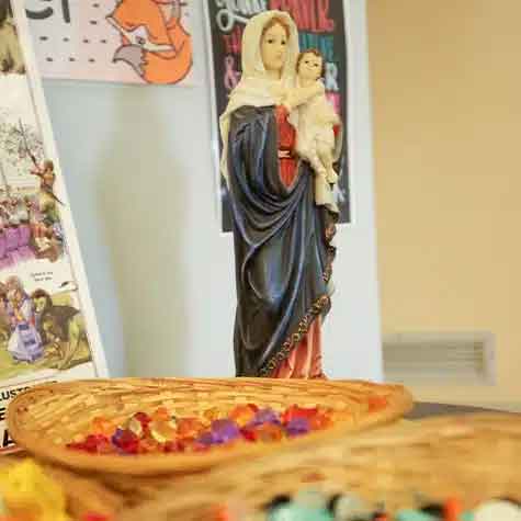 Religious classroom display featuring Marian statue and faith-based learning resources